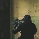 man in black jacket holding rifle